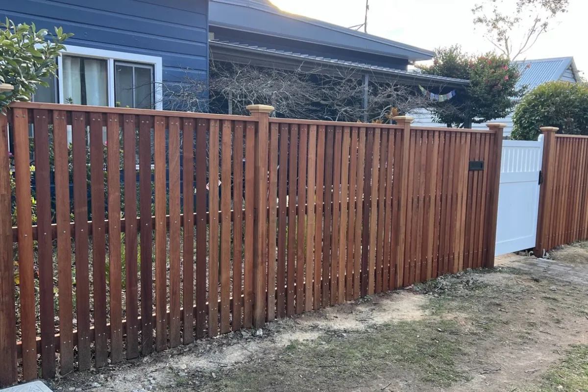 Timber batten front fence with white gate and integrated letterbox